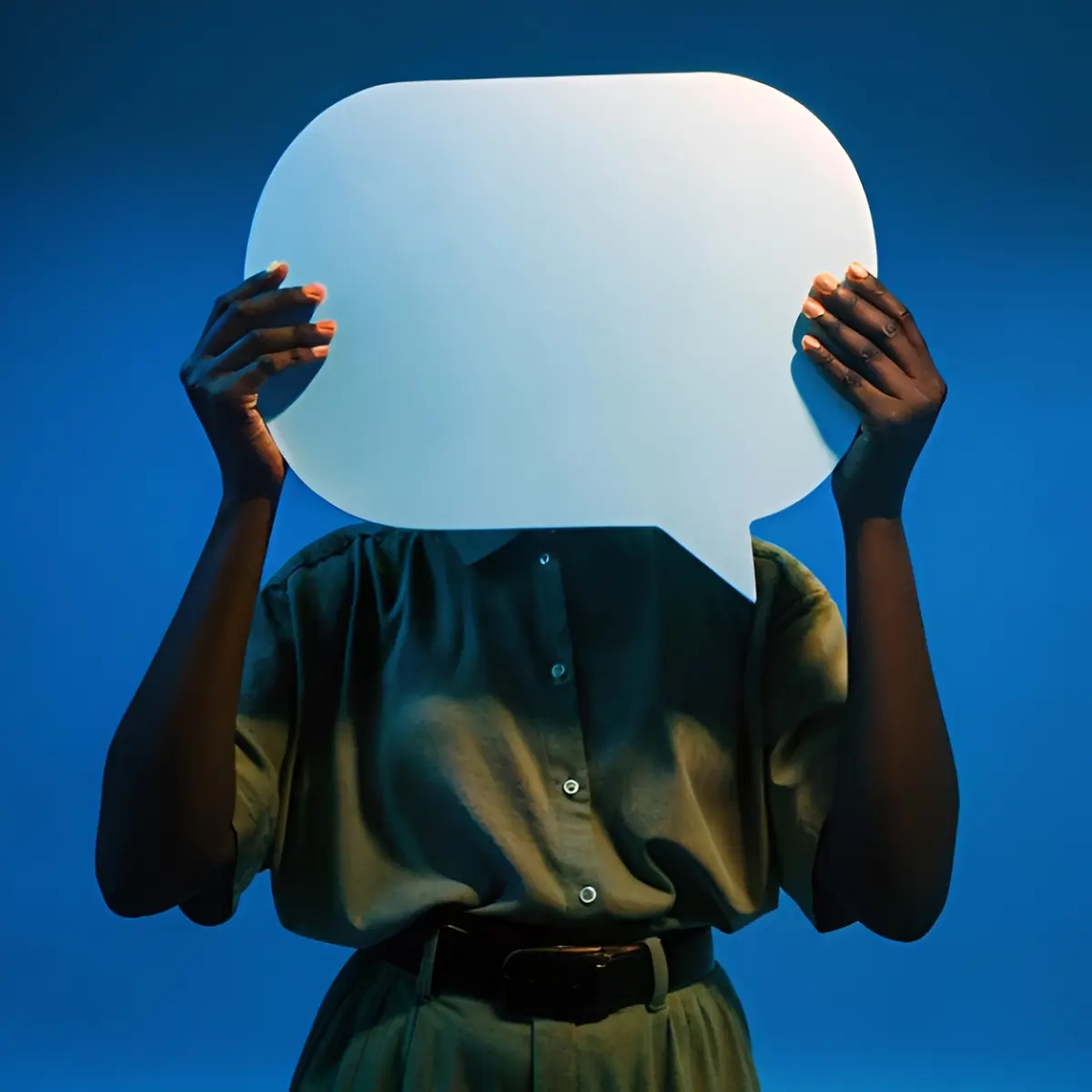 A person holding a large blank speech bubble in front of their face