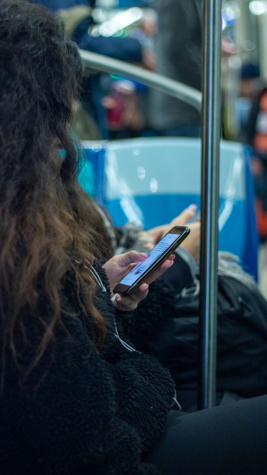 A commuter using a phone on a train