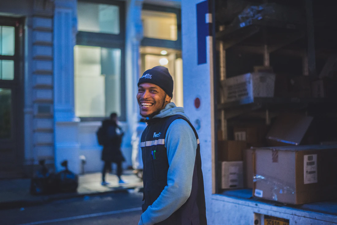 A delivery worker standing beside a parked truck
