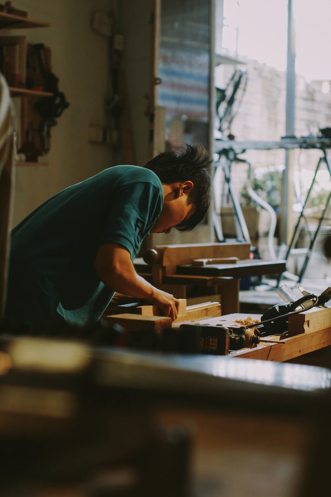 A carpenter working on wood in a workshop